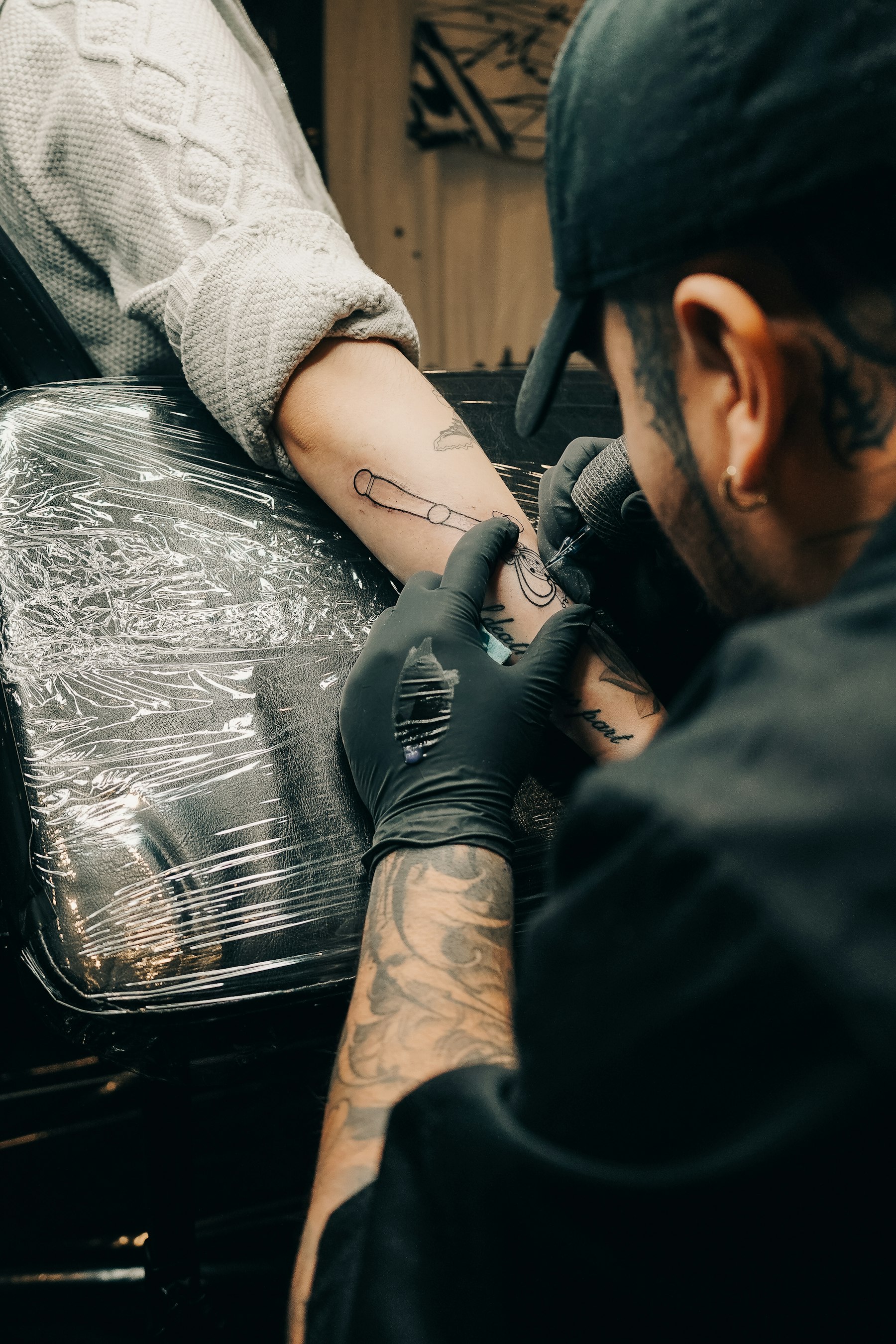 Tatuador trabajando en cabina sobre una muñeca